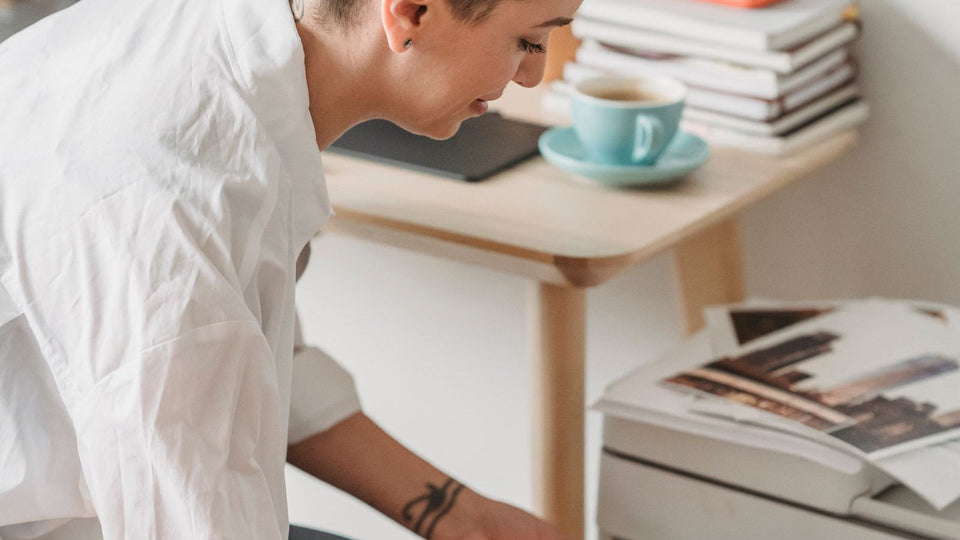 Woman preparing a pet portrait image on a laptop next to her home printer
